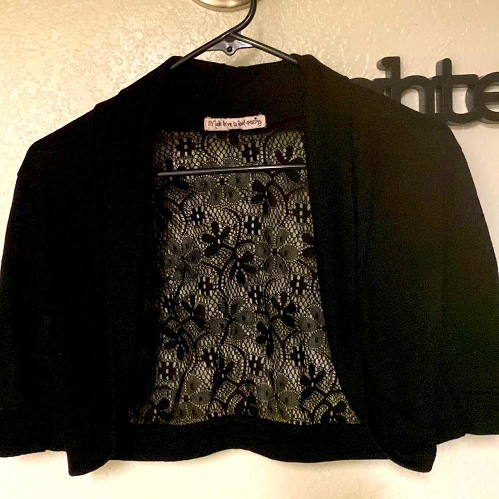 Black colored, open, lace back, cropped, short sleeve, shoulder shrug.
